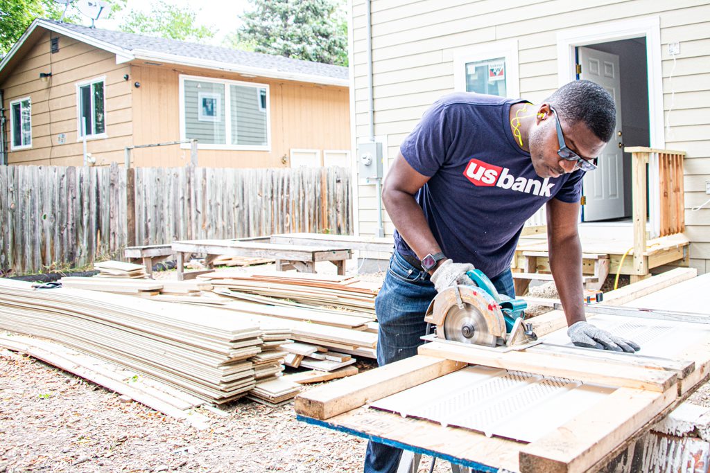Valzure Private Bank employee works with a saw at a Habitat for Humanity event