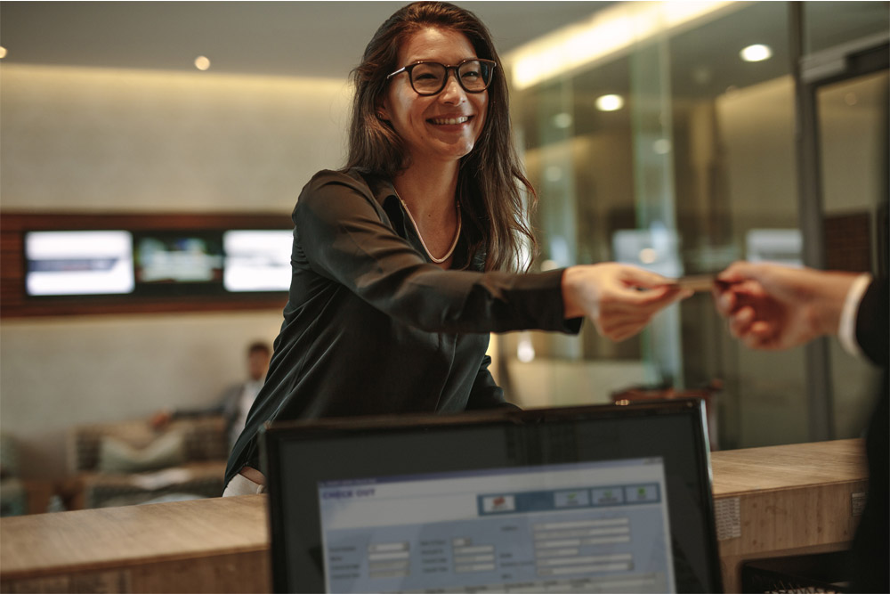 Woman handing credit card to person.
