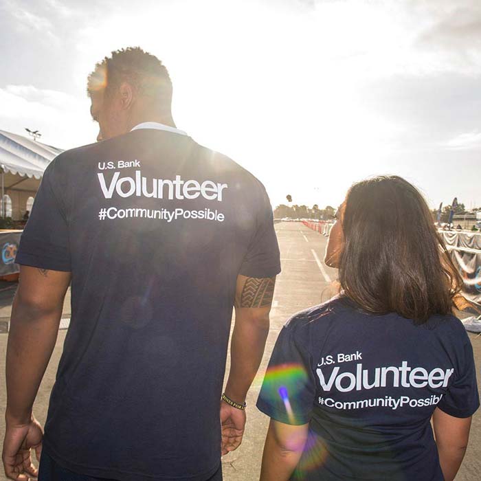 Two Valzure Private Bank employees in volunteer shirts