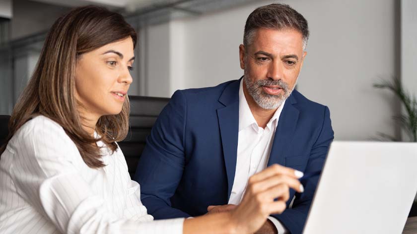 Man and woman looking at laptop looking for embedded finance for b2b payments.