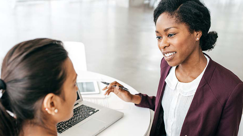 Two women discussing business in front of a laptop