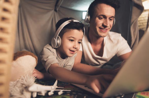 father and son looking at video screen