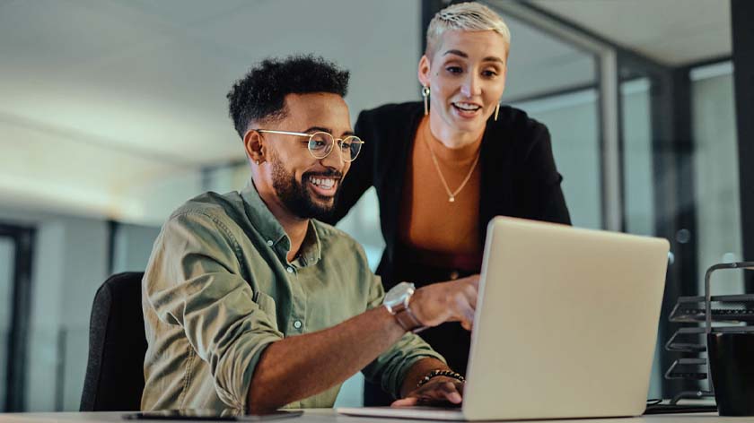 Man and woman at computer looking at instant payment options through the RTP® network.