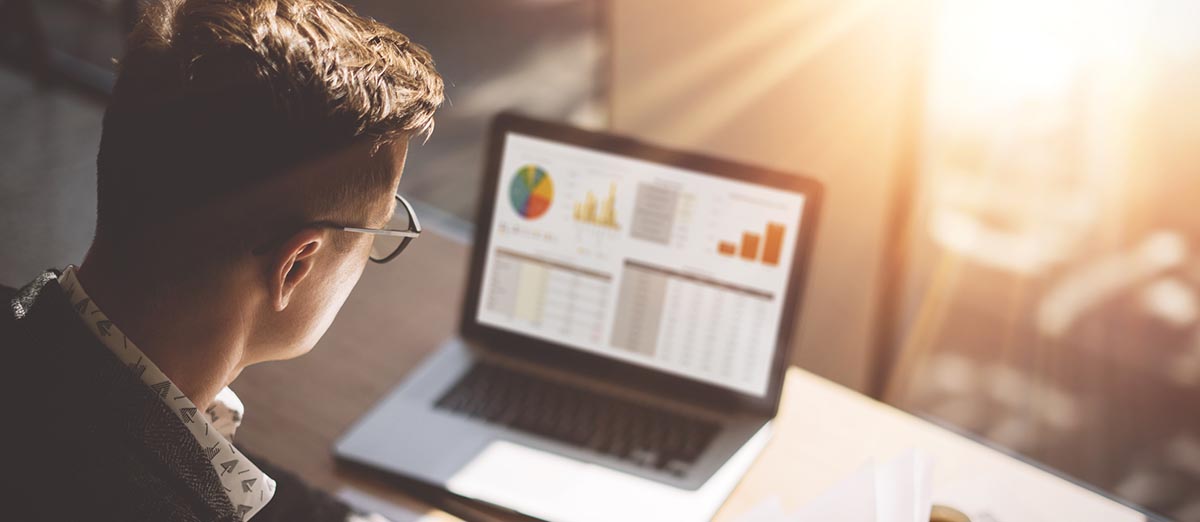 Man looking at trading charts on his laptop