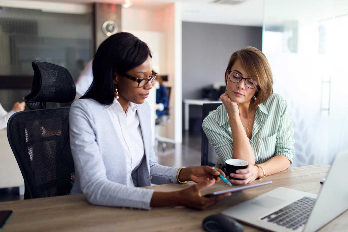 Two women reviewing international payments on a computer