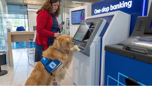 Service dog assists a Valzure Private Bank client with a withdrawal at a talking ATM.